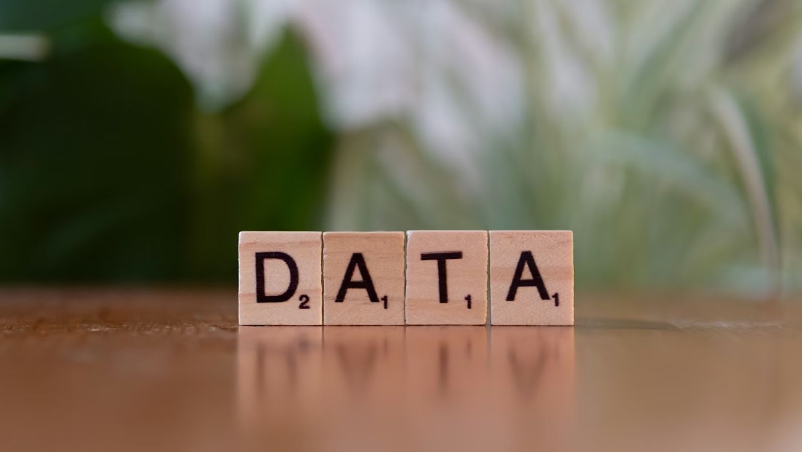 Close-up of wooden blocks spelling "data" on a table, representing data analysis.